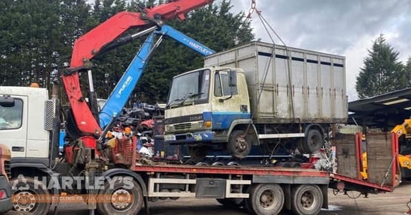 Scrap Metal being collected on the back of a truck with a crane