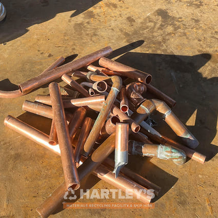 Scrap Metal Copper Pipes in a pile being weighed